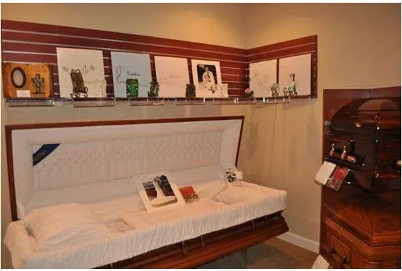 A room with a coffin and pictures on the wall