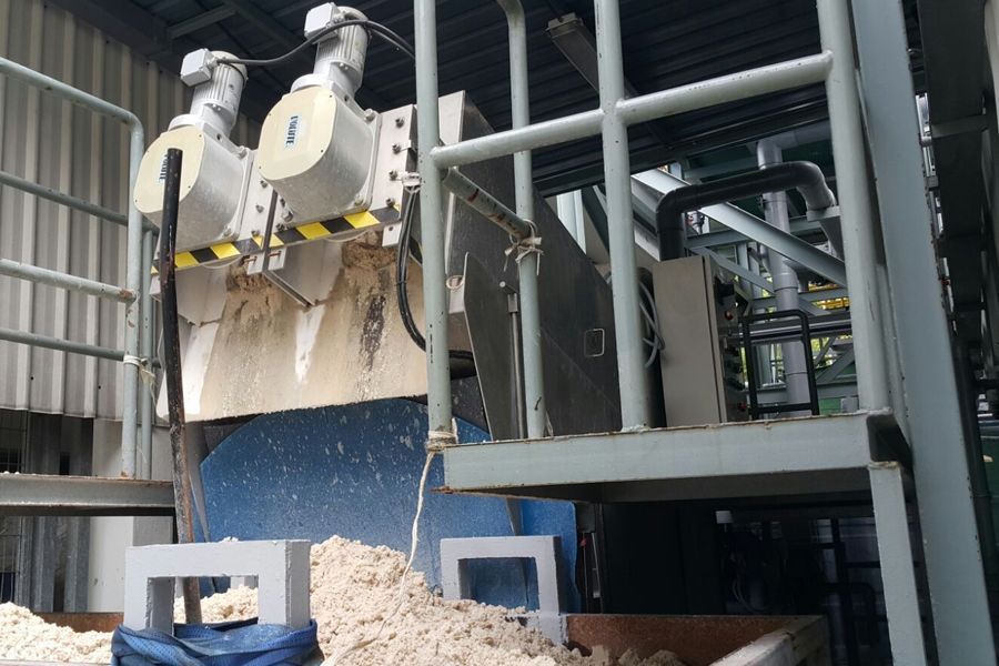 Industrial machinery processing blue material on a factory line