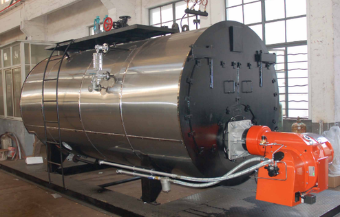 Large stainless steel industrial boiler with an orange burner unit in a factory setting