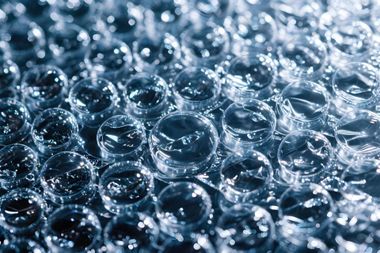 Close-up of clear water bubbles and ripples on a blue surface
