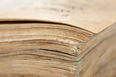 Close-up of the worn pages and spine of an old, yellowed book