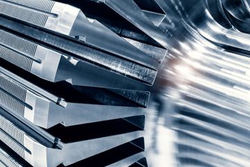 Abstract close-up of metallic blades or fins with a bright blurred reflection on the right