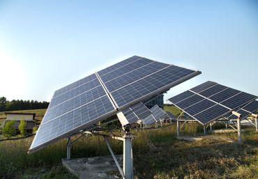 Solar panels in a field under a clear blue sky