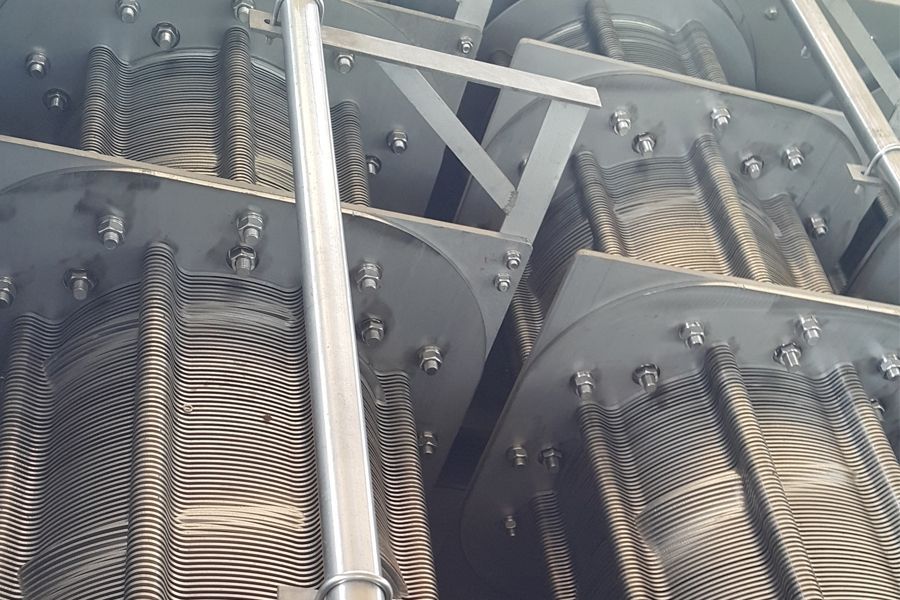 Industrial metal machinery with rows of gears and springs inside a mechanical assembly