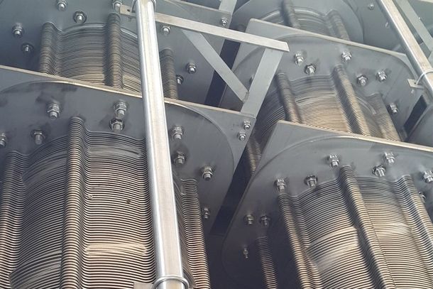 Industrial metal machinery with rows of gears and springs inside a mechanical assembly