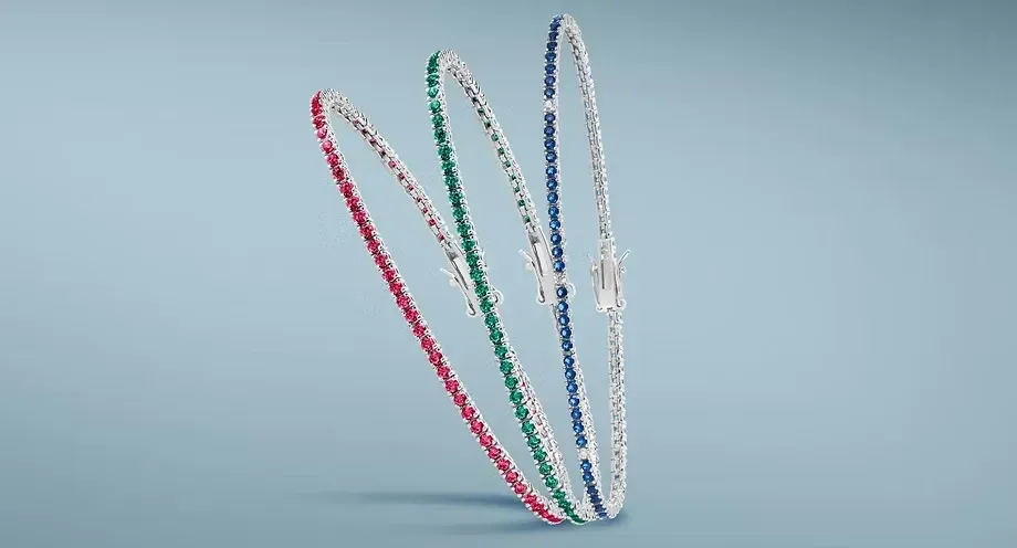 Tre hula hoop colorati appoggiati l’uno all’altro su uno sfondo azzurro chiaro