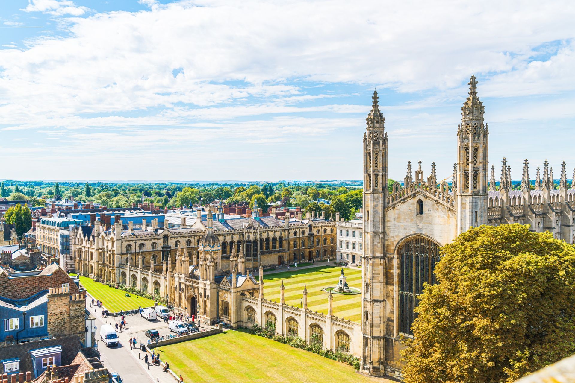 Cambridge University buildings with grassy lawns, blue sky.