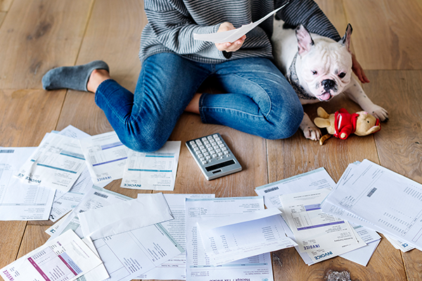 a woman is sitting on the floor with a dog and a calculator .