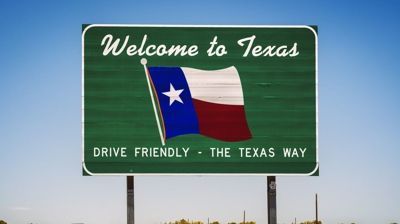 “Welcome to Texas” roadside sign with Texas flag and “Drive Friendly - The Texas Way” slogan