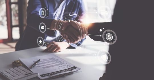 Person signing a document at a desk with floating digital finance icons.