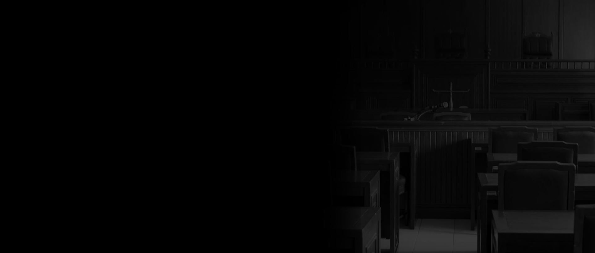 Dark, nearly black room with rows of chairs faintly visible on the right side.