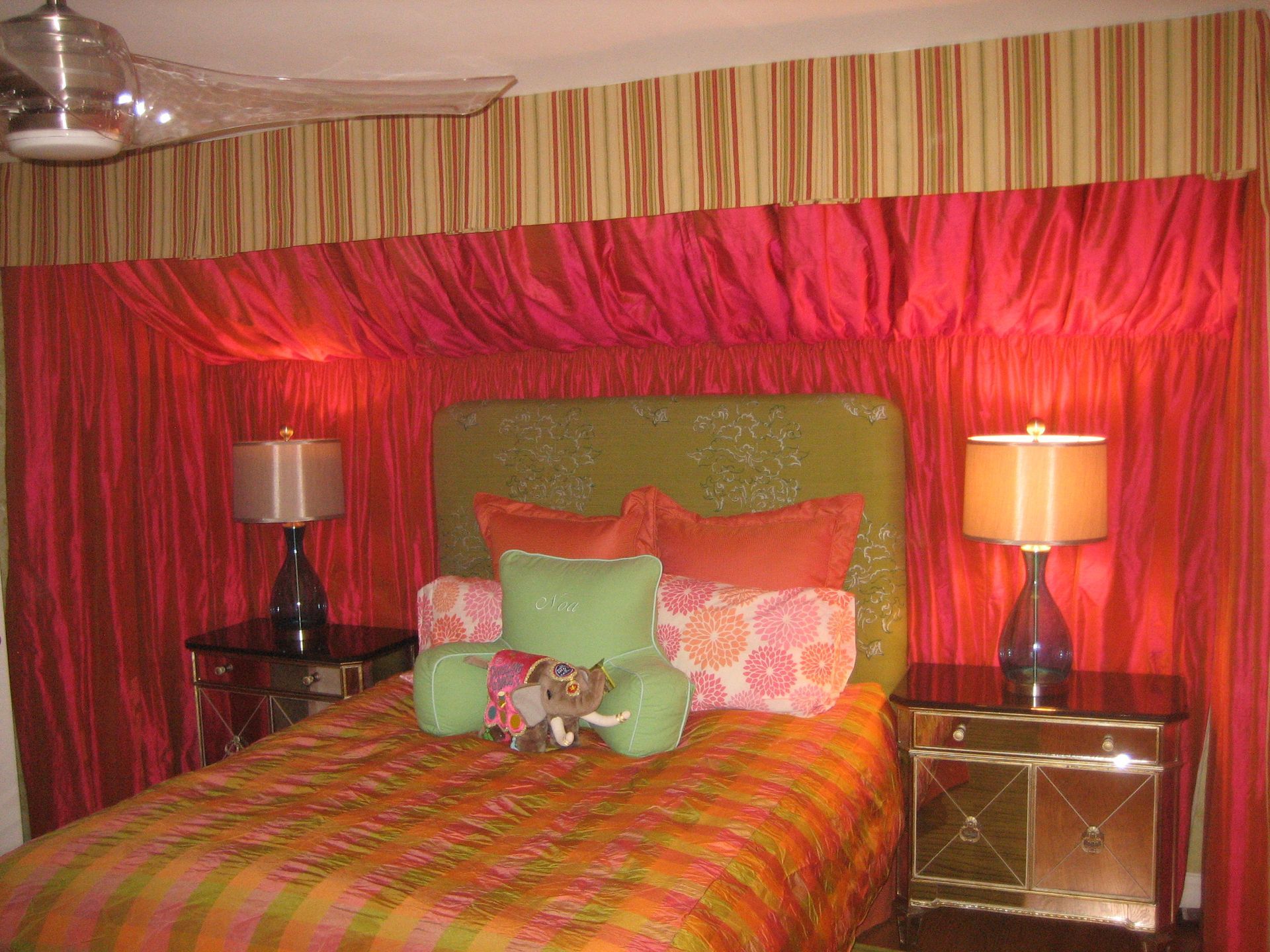 A bedroom with a bed , two lamps and a ceiling fan
