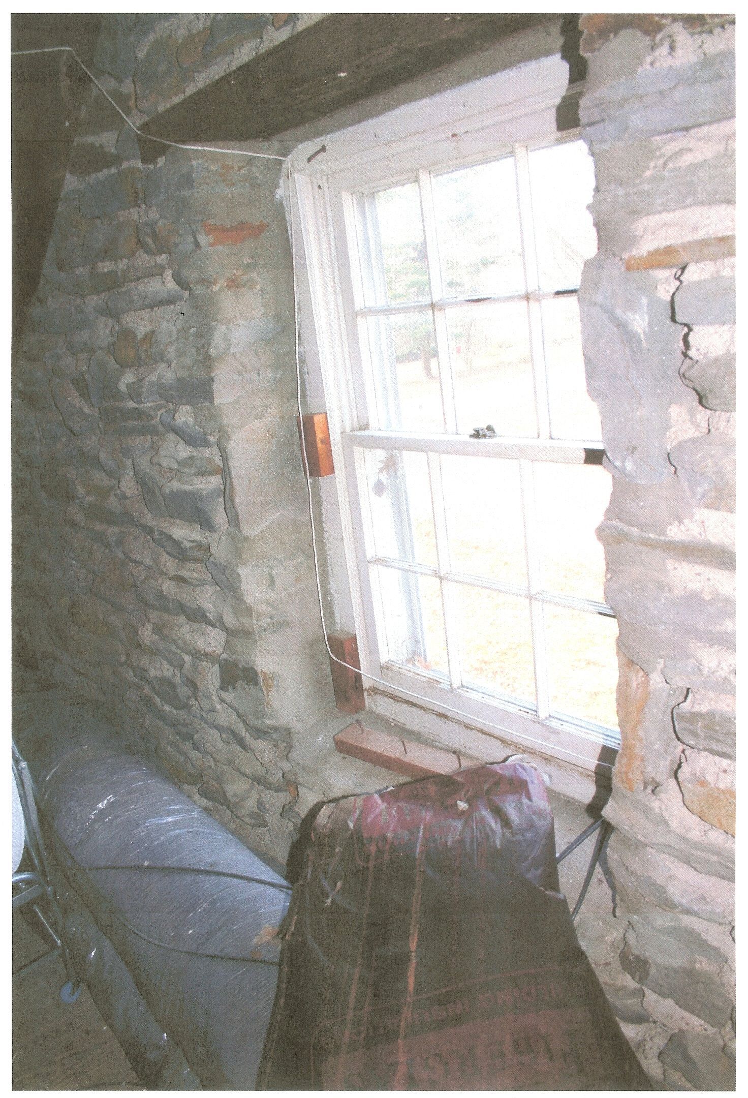 A picture of a window in a stone wall