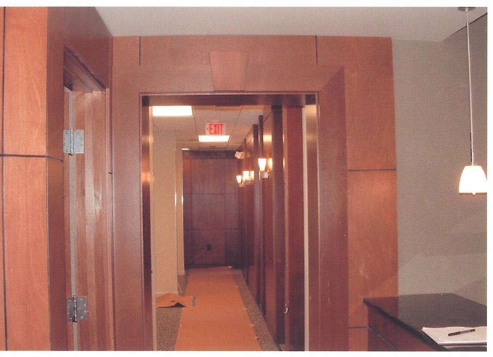 A hallway with a red exit sign on the wall