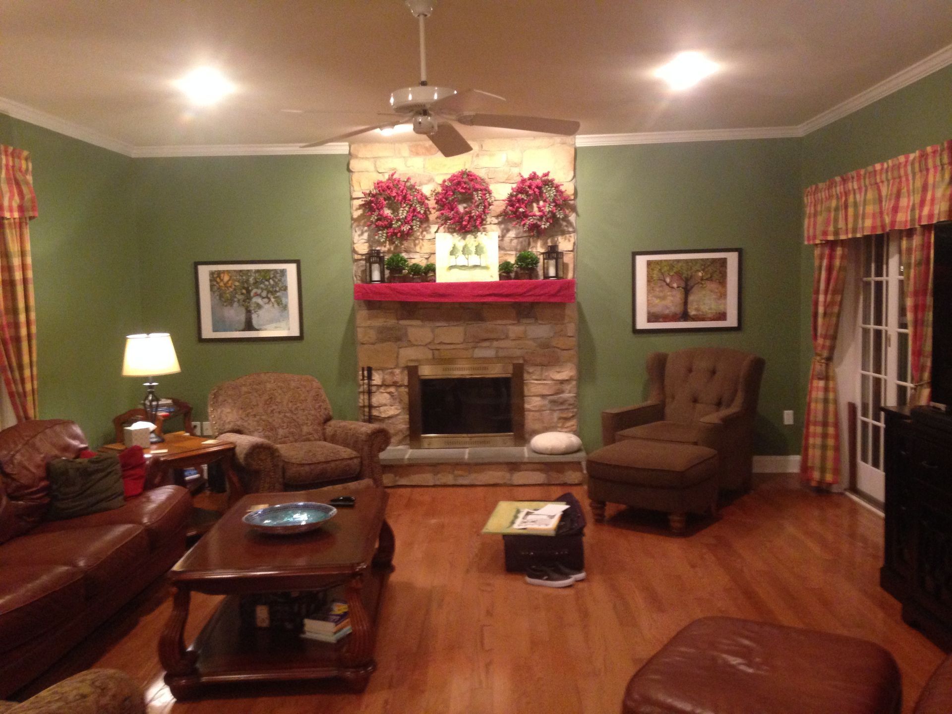 A living room with green walls and a fireplace