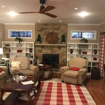 A living room filled with furniture and a fireplace with a ceiling fan.