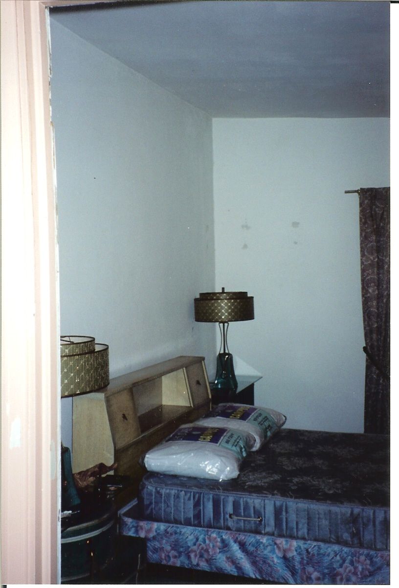 A bedroom with a bed and a lamp in it