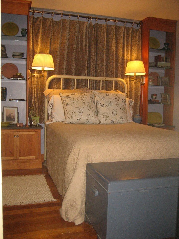 A bedroom with a bed and two lamps on the wall
