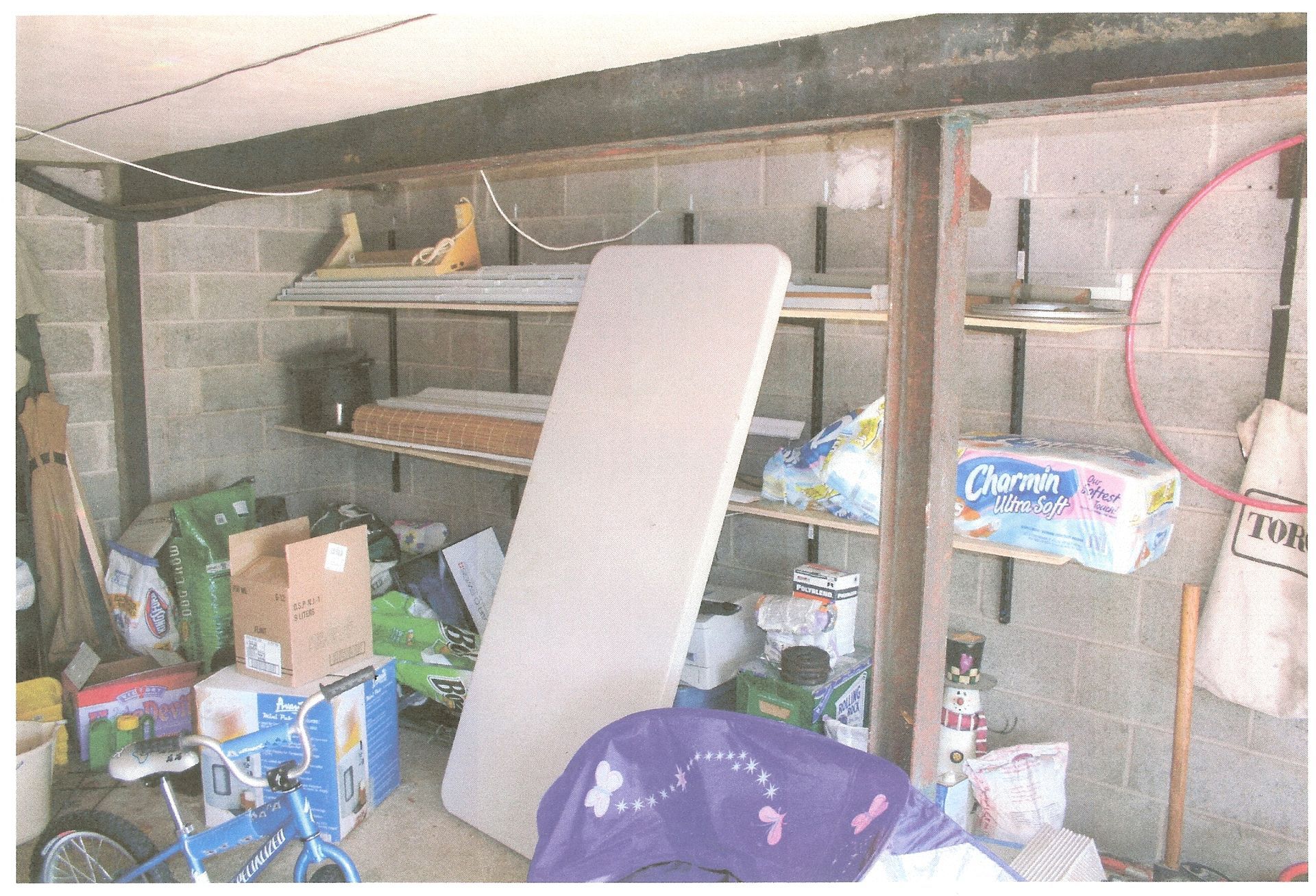 A garage filled with lots of items including a mattress