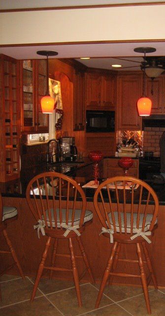 A kitchen with two wooden chairs sitting at a counter