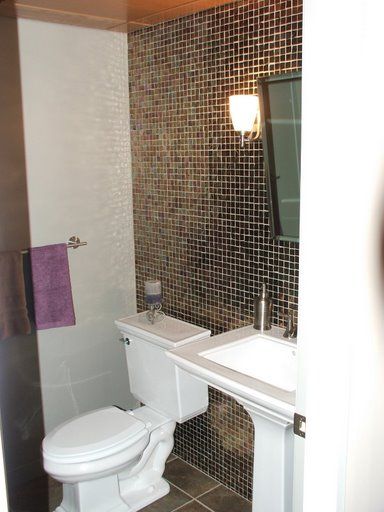 A bathroom with a toilet , sink and mirror