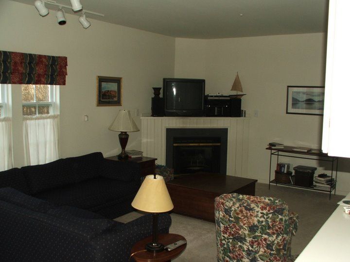 A living room with a black couch and a fireplace