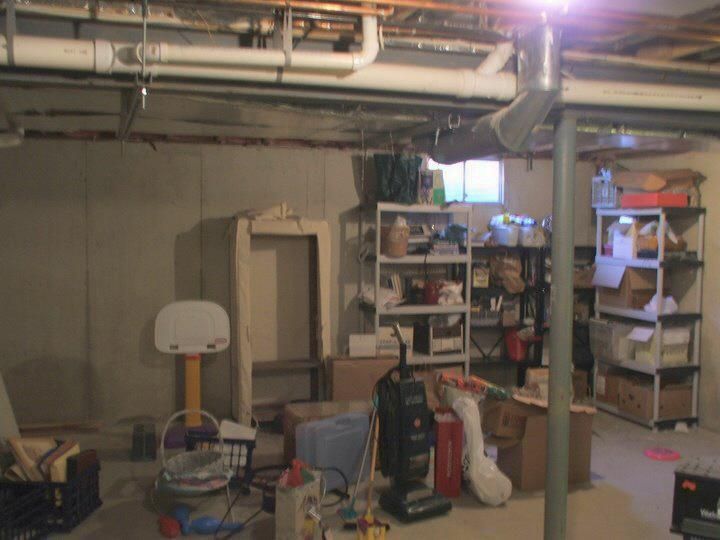 A basement with a basketball hoop and a vacuum cleaner