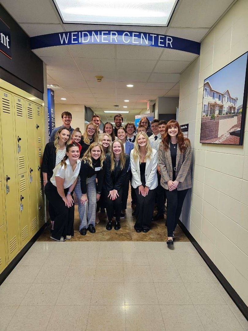 A group of people standing in a hallway under a 