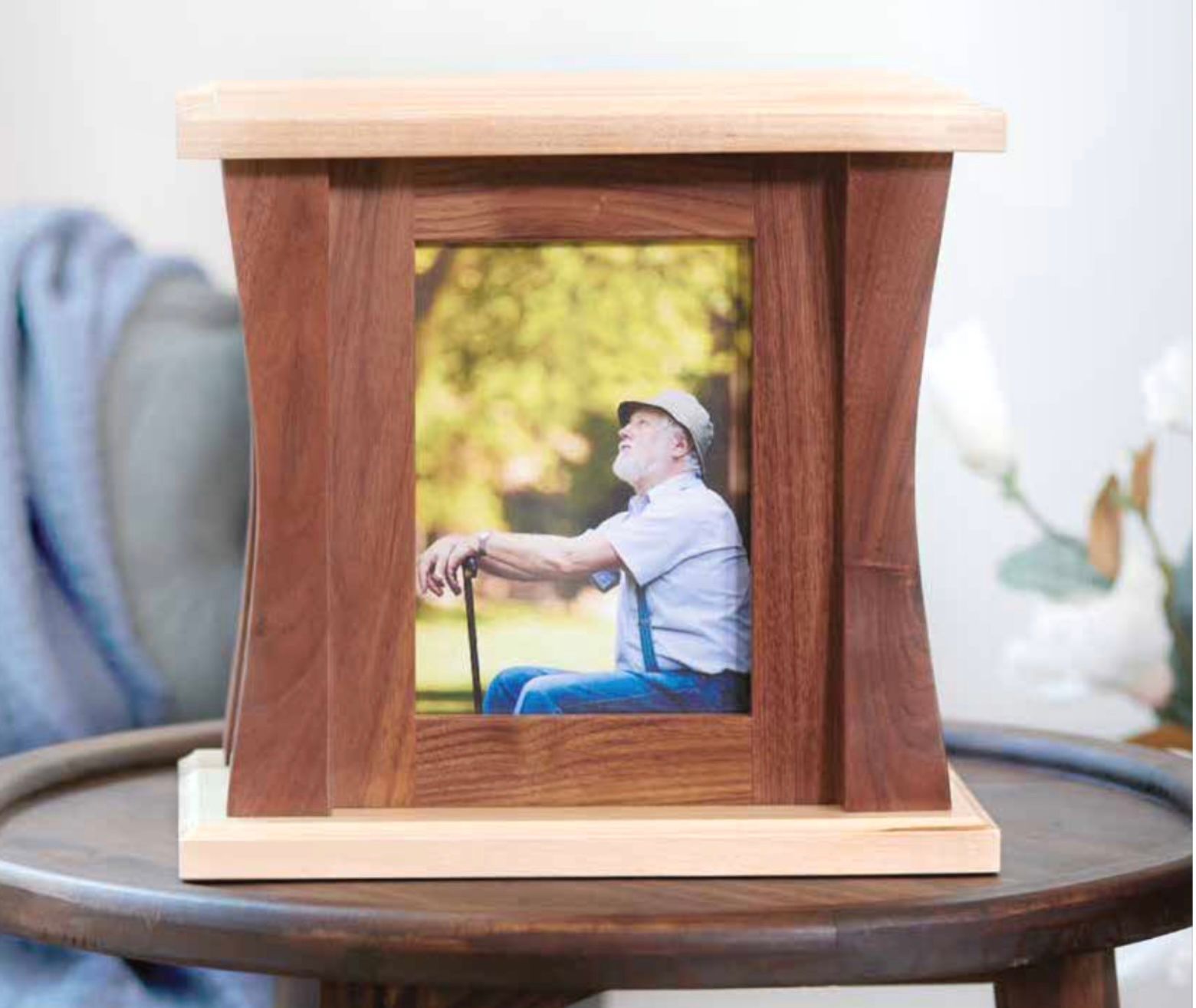 Wooden tabletop photo frame with a small seated man photo centered inside
