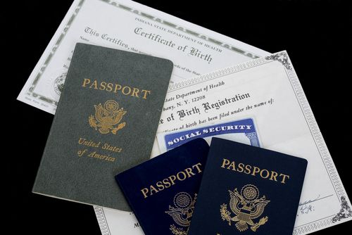 Assorted passports and birth certificates arranged on a light surface