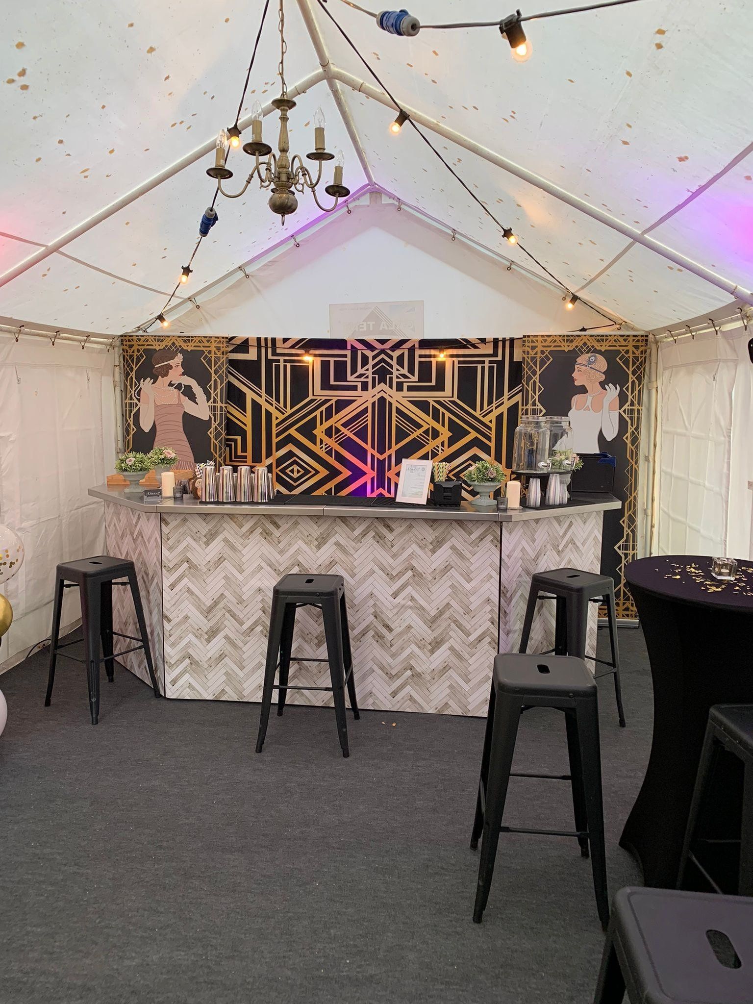 A tent with a bar and stools inside of it.