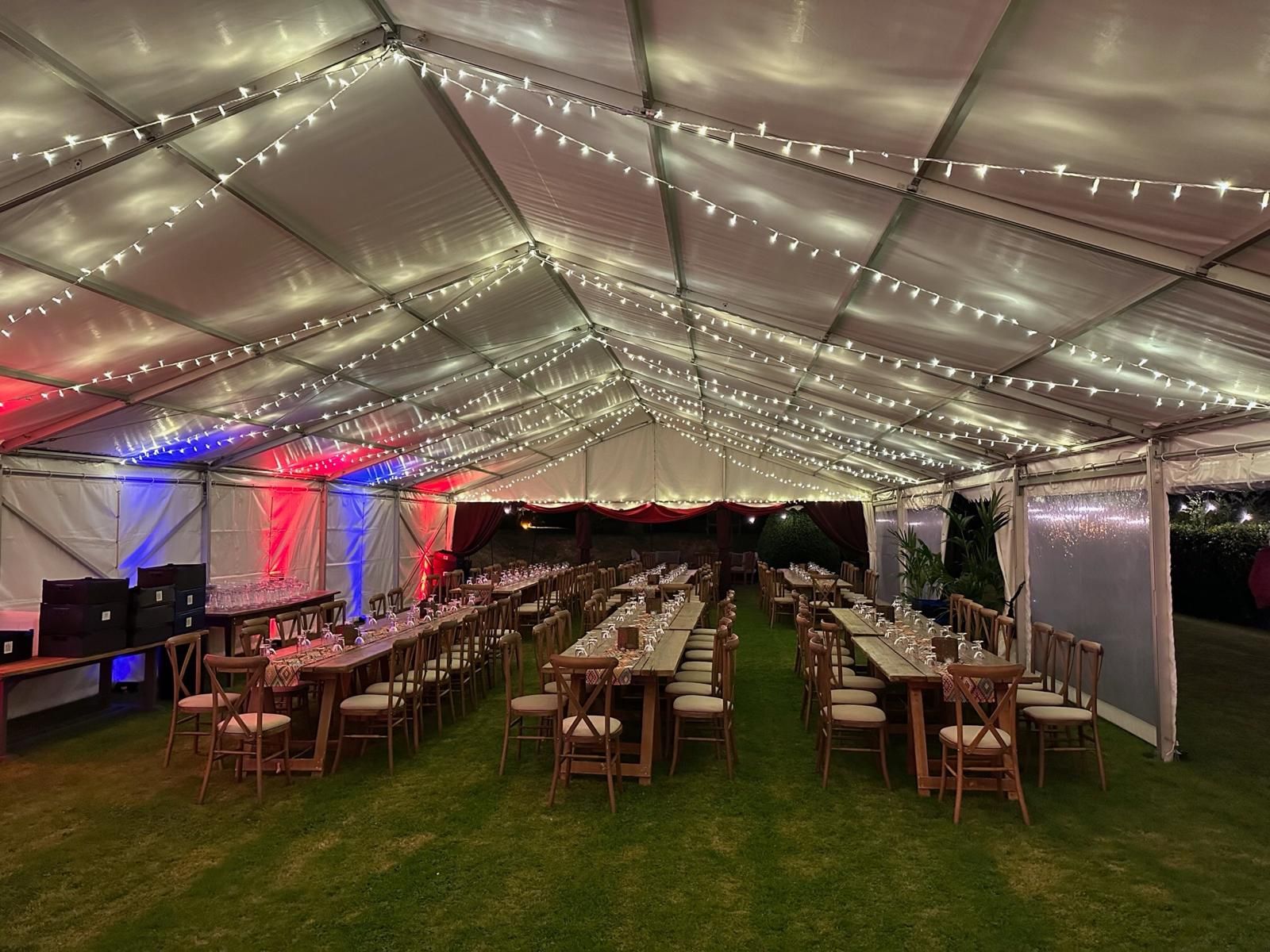 A large tent with tables and chairs underneath it.
