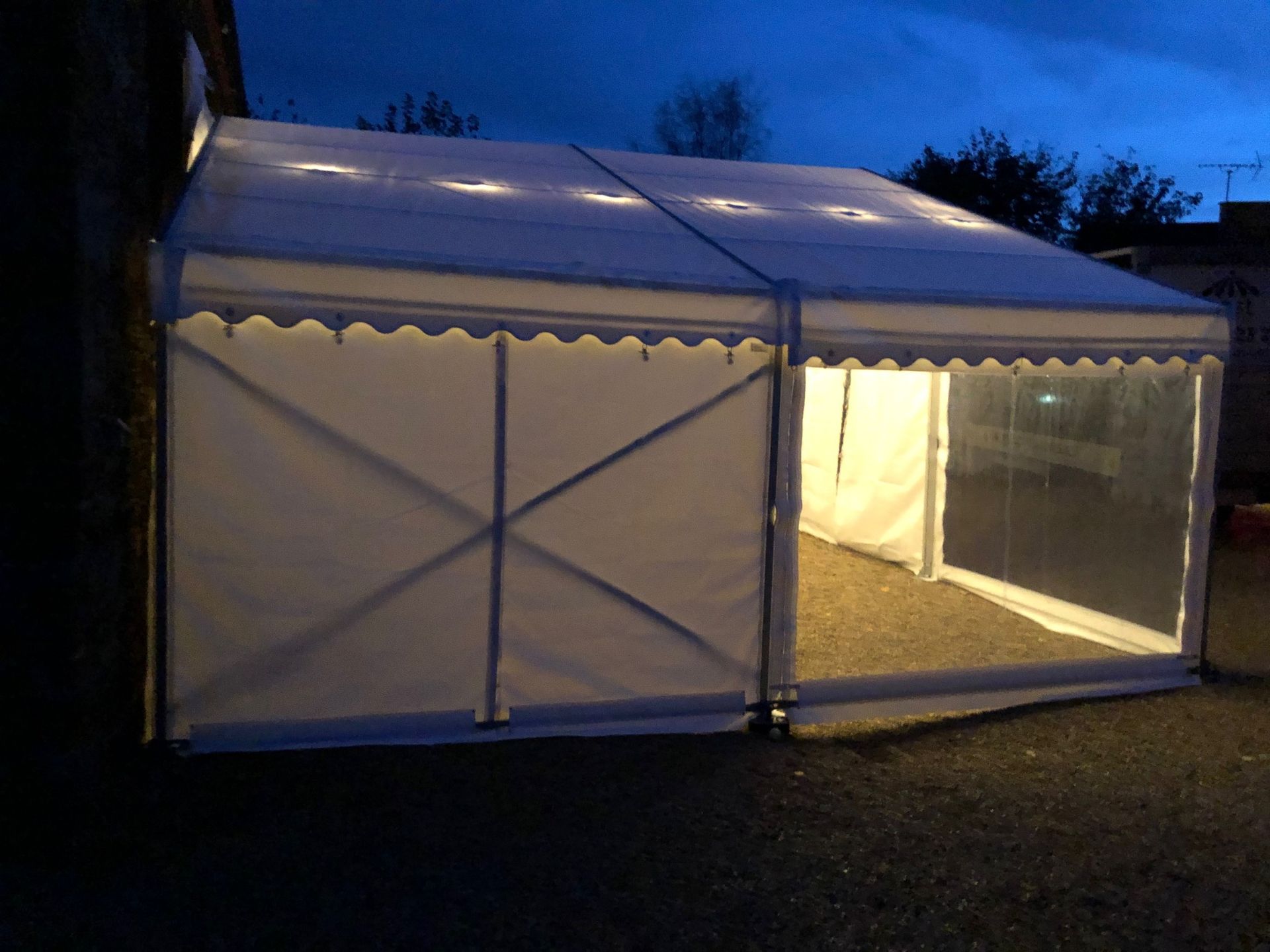 A large white tent is lit up at night