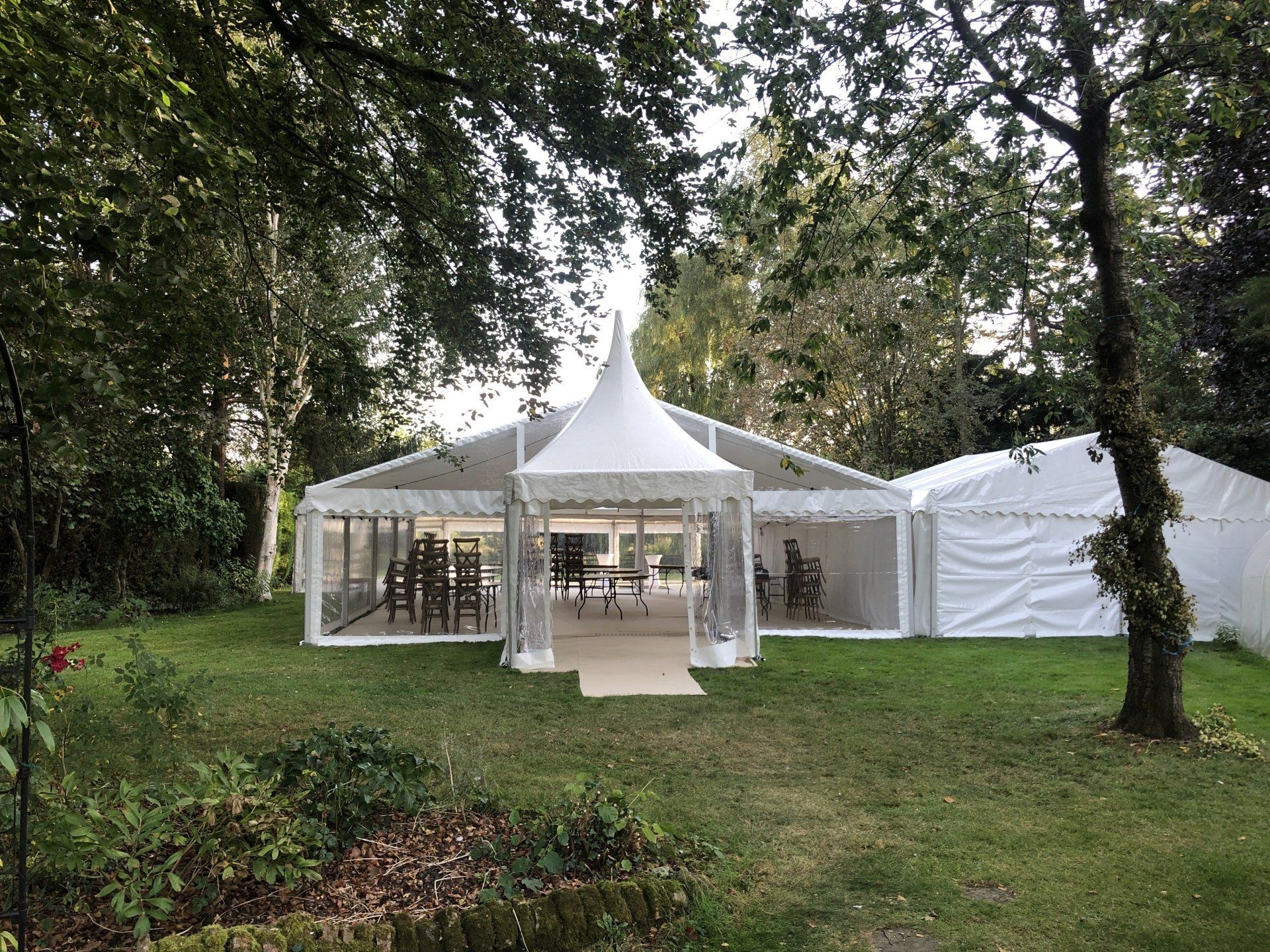A large white tent is sitting in the middle of a lush green field.