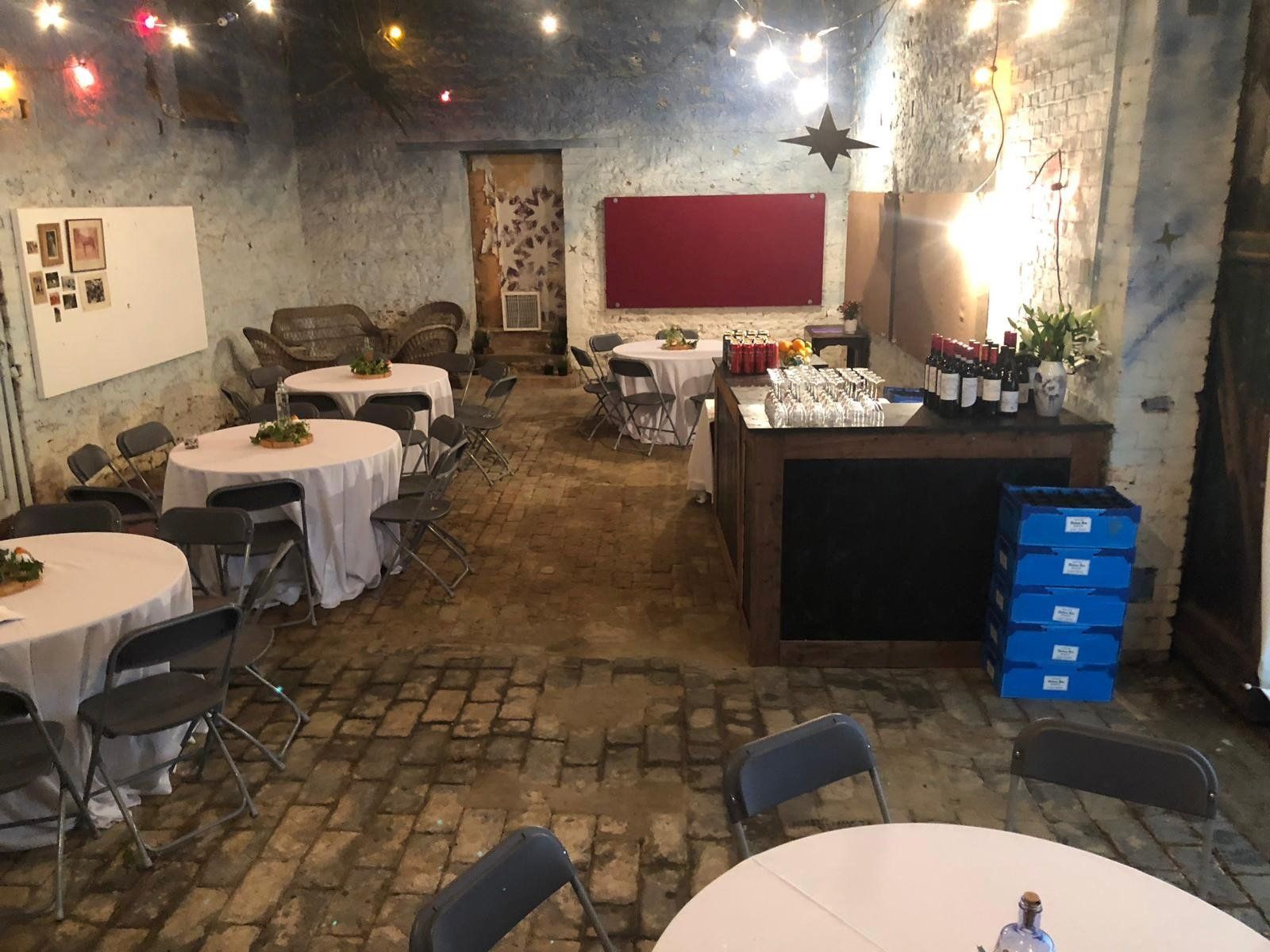 A large room with tables and chairs set up for a party.