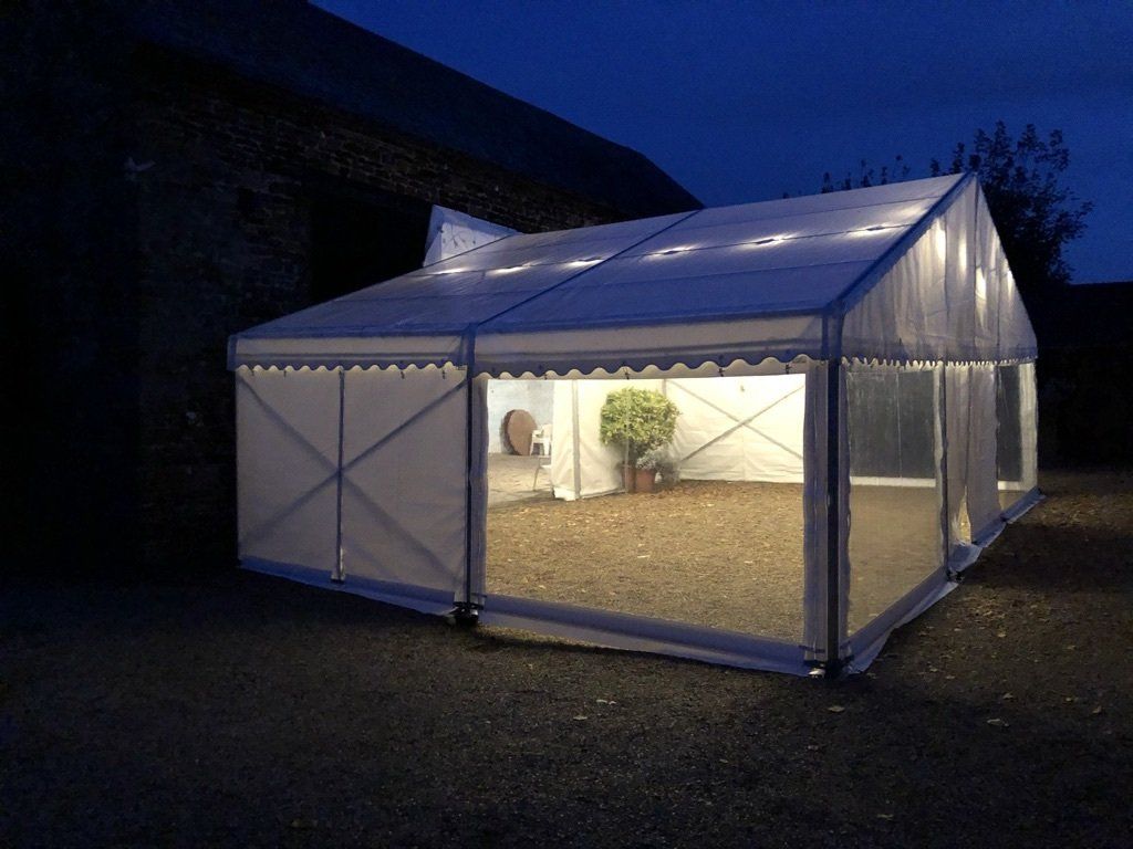 A large white tent is lit up at night