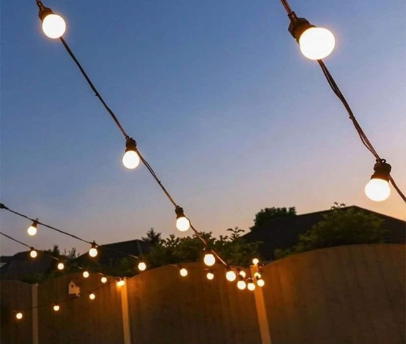 A string of lights hanging over a wooden fence