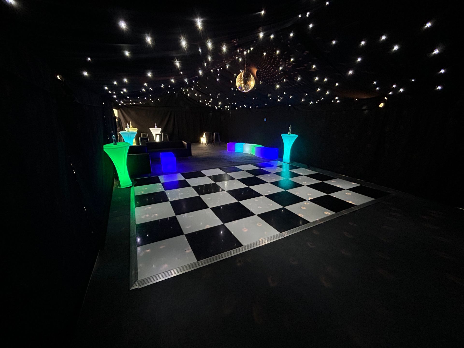A black and white checkered dance floor with a disco ball in the ceiling.