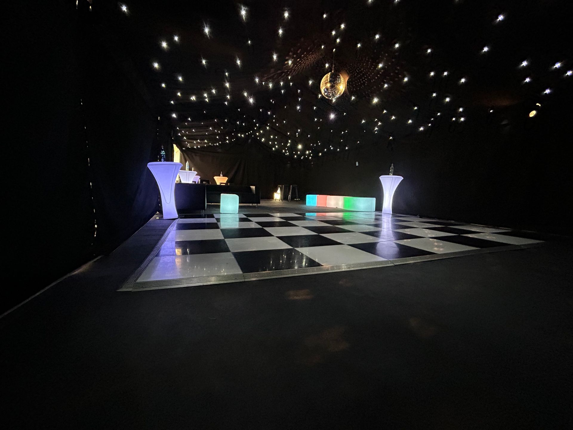 A black and white checkered dance floor with lights on the ceiling.