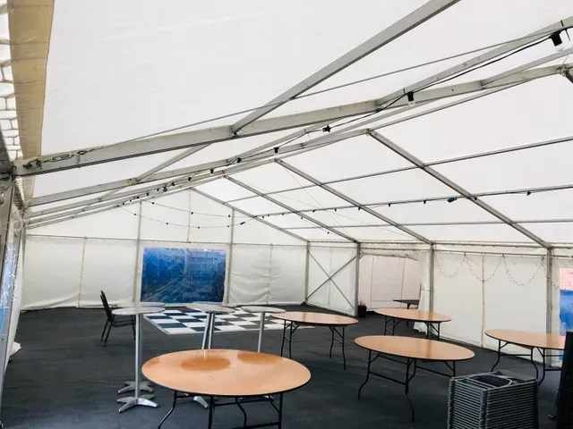 A large tent with tables and chairs inside of it