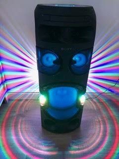 A tower speaker with lights on it is sitting on a wooden floor.