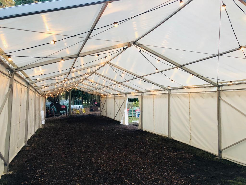 A large white tent with lights hanging from the ceiling