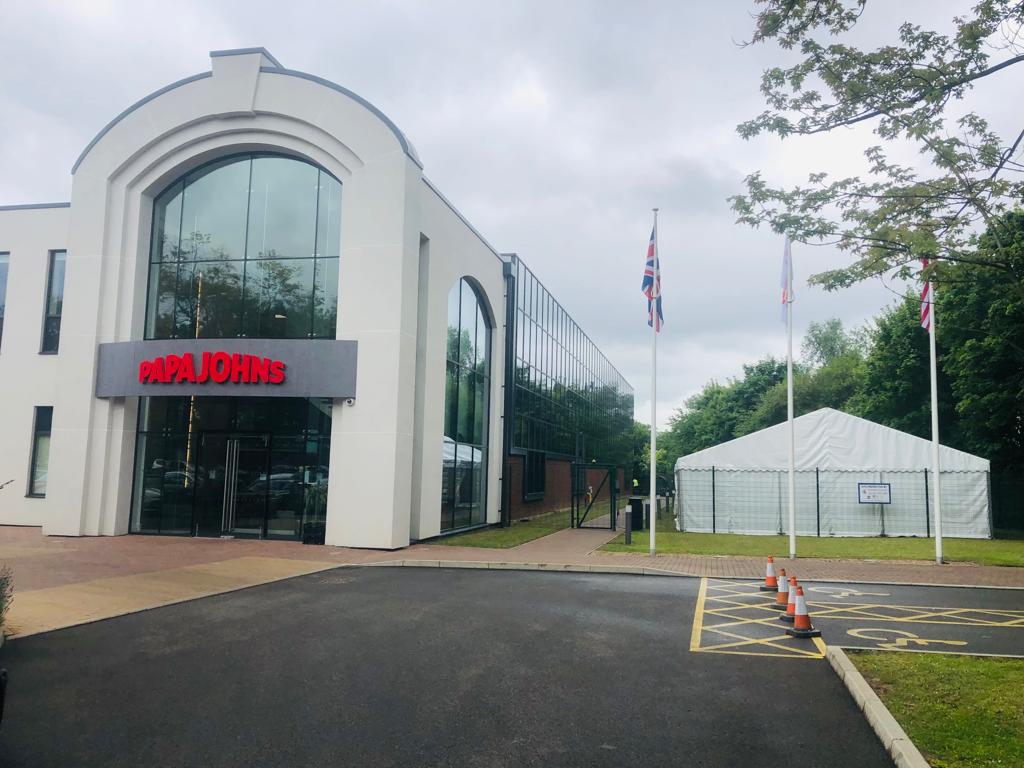 A large white building with a tent in front of it.