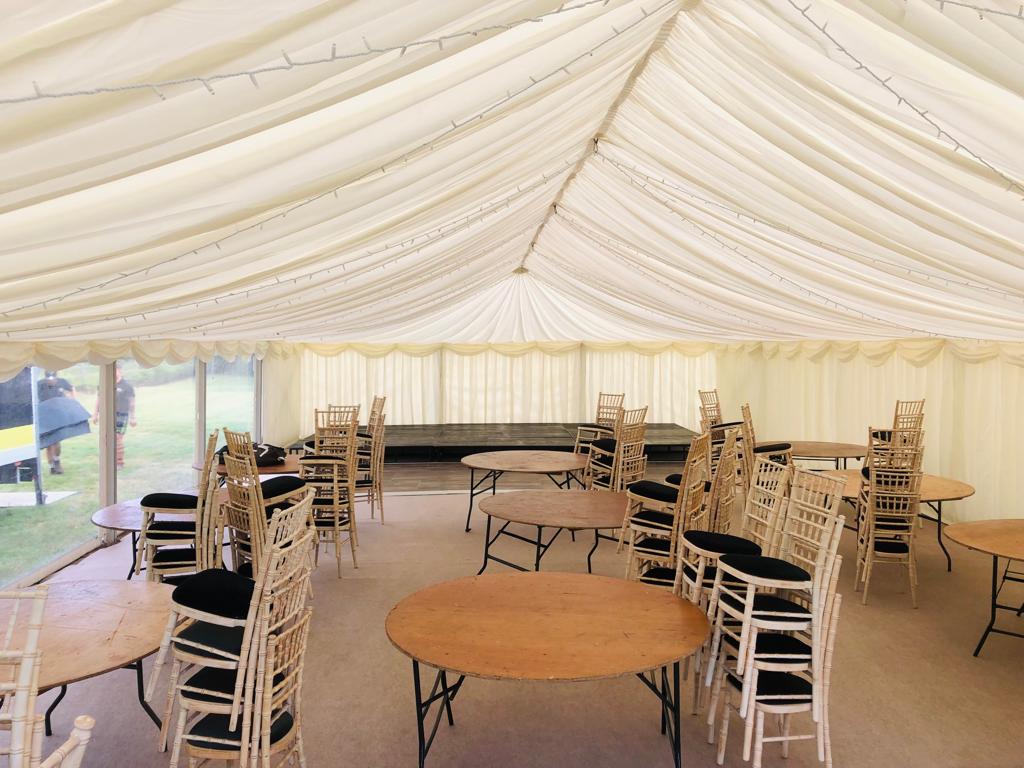 A large tent with tables and chairs inside of it
