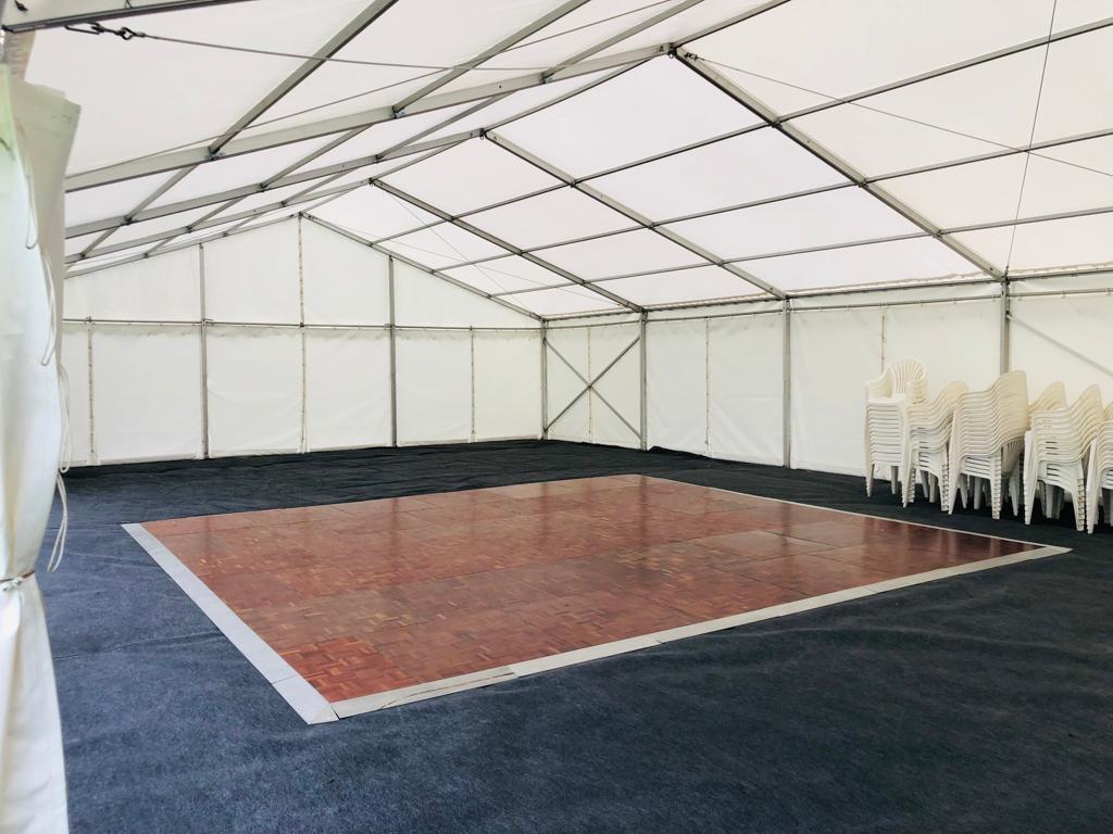 A large tent with a dance floor in the middle