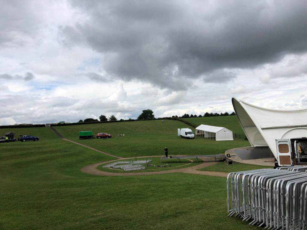 A large white tent is sitting in the middle of a grassy field.
