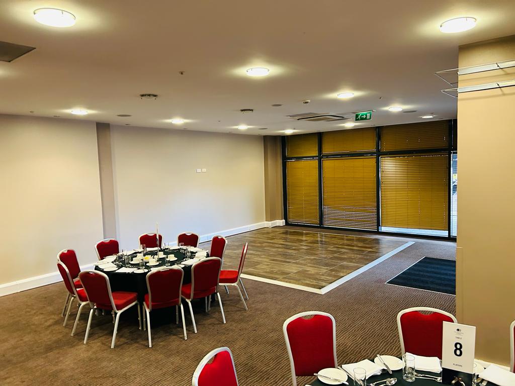 A large room with tables and chairs and a dance floor.