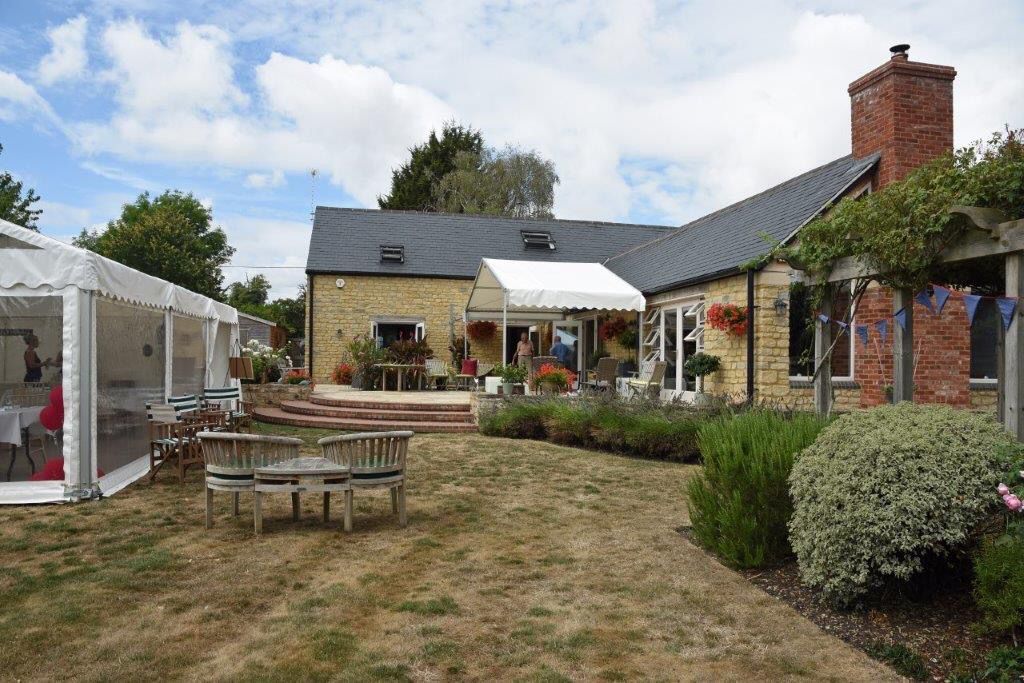 A large house with a white tent in front of it.