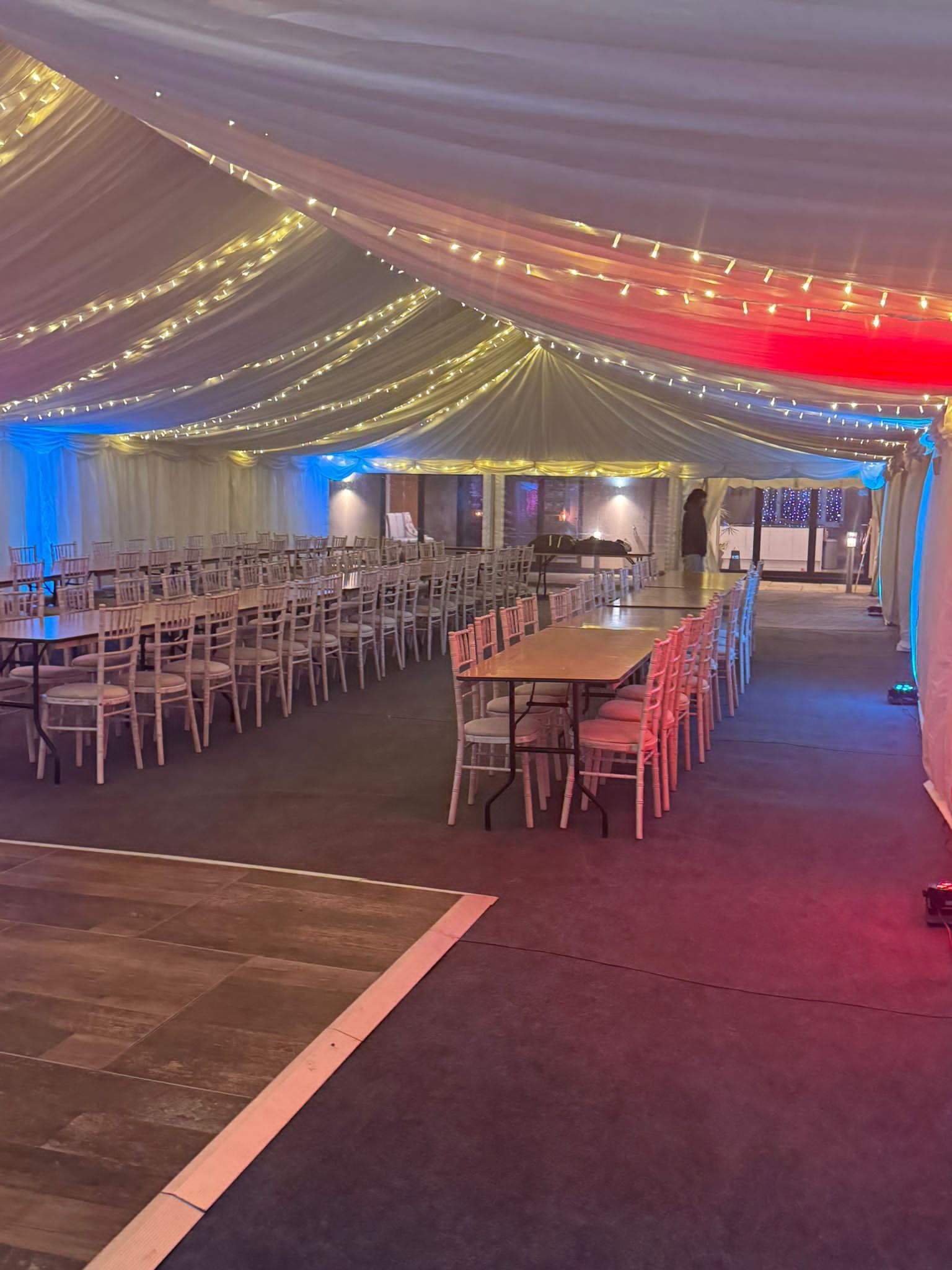 A large room with tables and chairs under a tent.