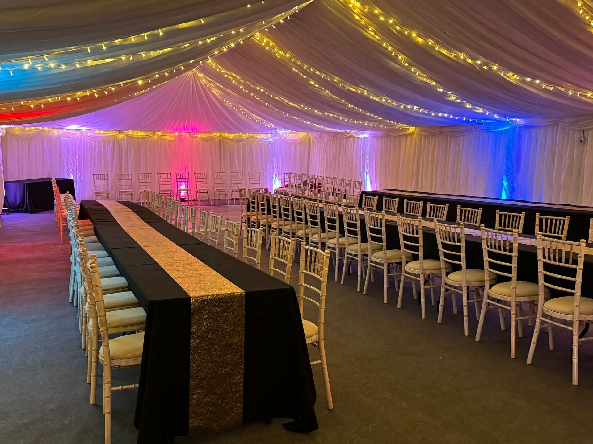 A large room with tables and chairs under a tent.
